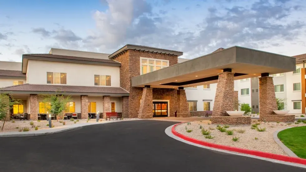 Welcoming entrance with lush landscaping and warm lighting invites a sense of community and comfort., Cadence Lakewood