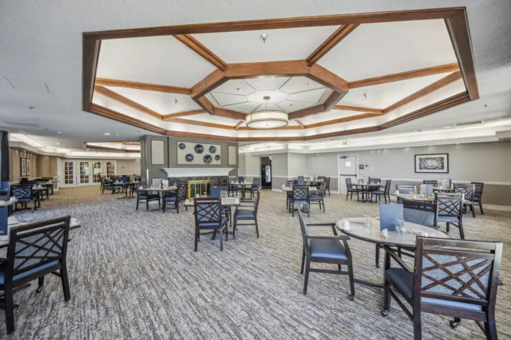 Spacious dining room with elegant wood accents offering a welcoming community atmosphere., Harvard Square Memory Care