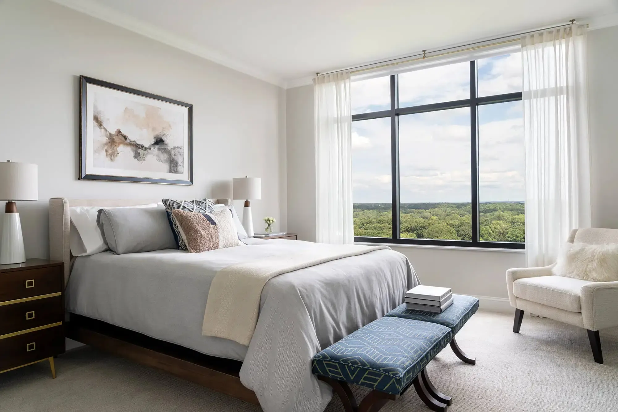 Modern bedroom featuring a queen-sized bed with gray linens and decorative pillows., The Cardinal at North Hills