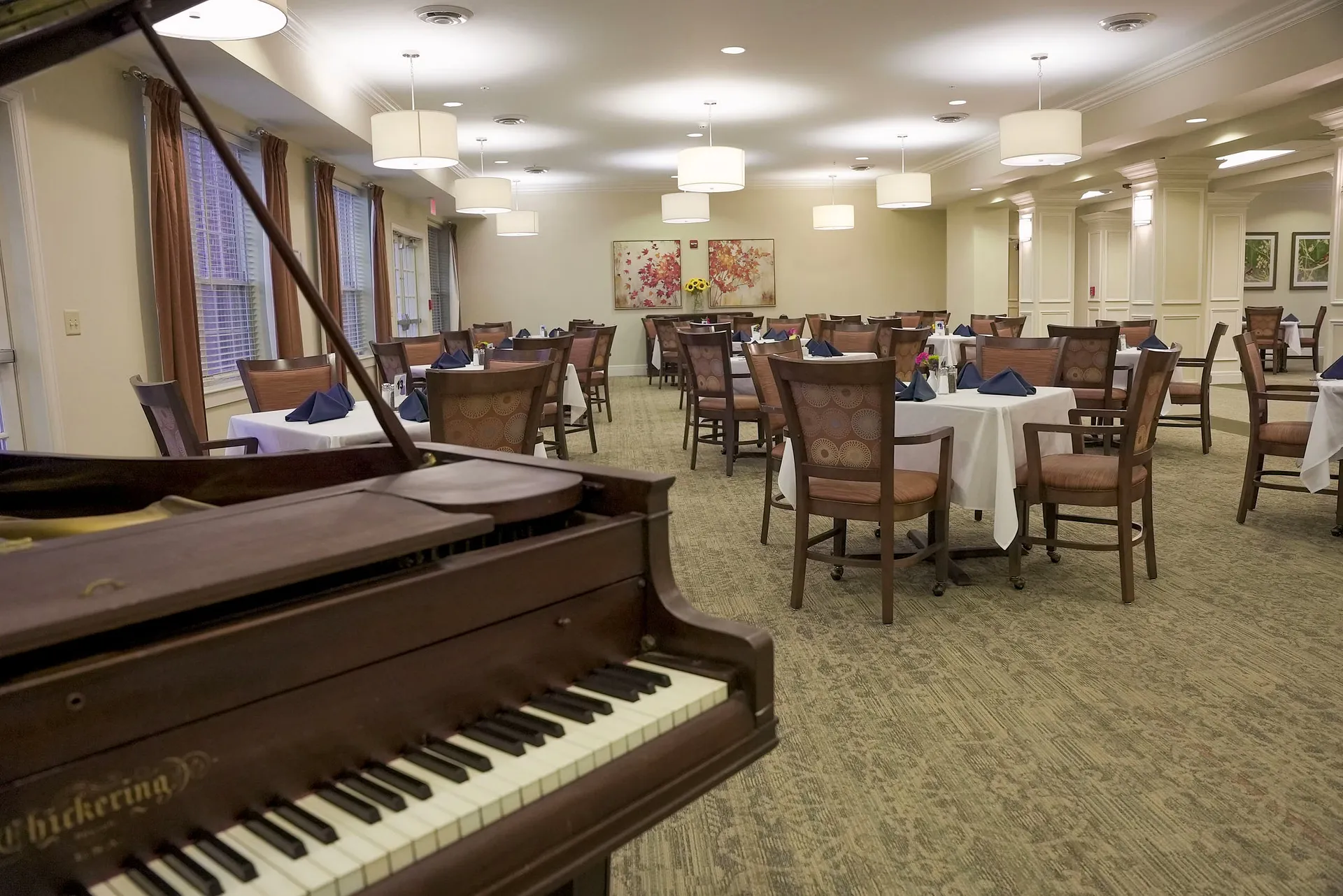 Elegant dining room with grand piano and round tables, Harmony at Chantilly, Assisted Living in Herndon, VA